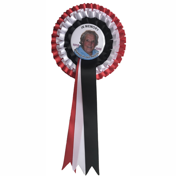 Funeral or memorial service rosette in red, blacj and white ribbon with a photo of a lady